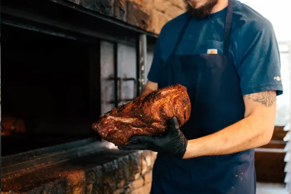 a man holding a roasted meat