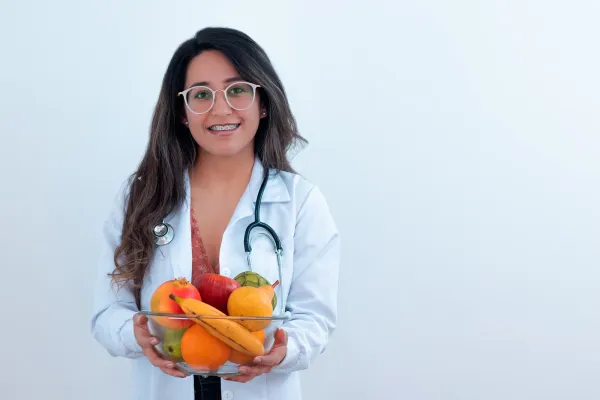 doctor holding a bowl of fresh fruit from her local farmer's market