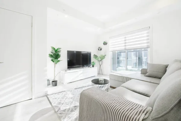 living room with white couch and flat screen on wall inside a rental property