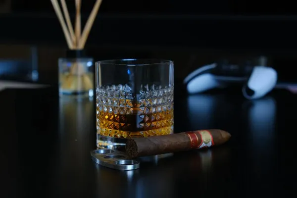 cigar near glass of whisky